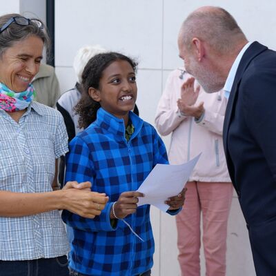 Bild vergr&ouml;&szlig;ern: Oberbürgermeister Martin Georg Cohn (rechts) übergibt die Urkunde an ein Mädchen und ihre Mutter.