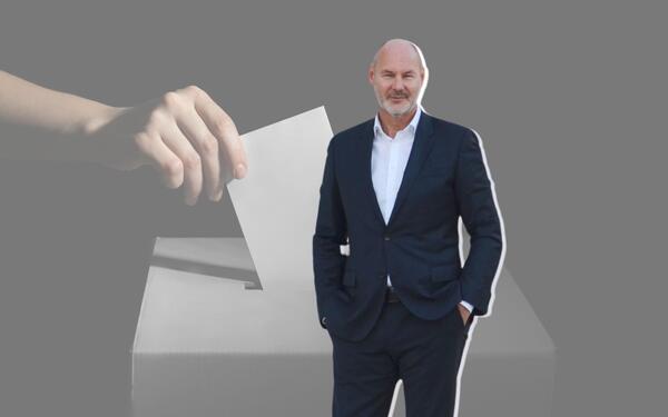 OB Cohn im Portrait, im Hintergrund eine Wahlurne.