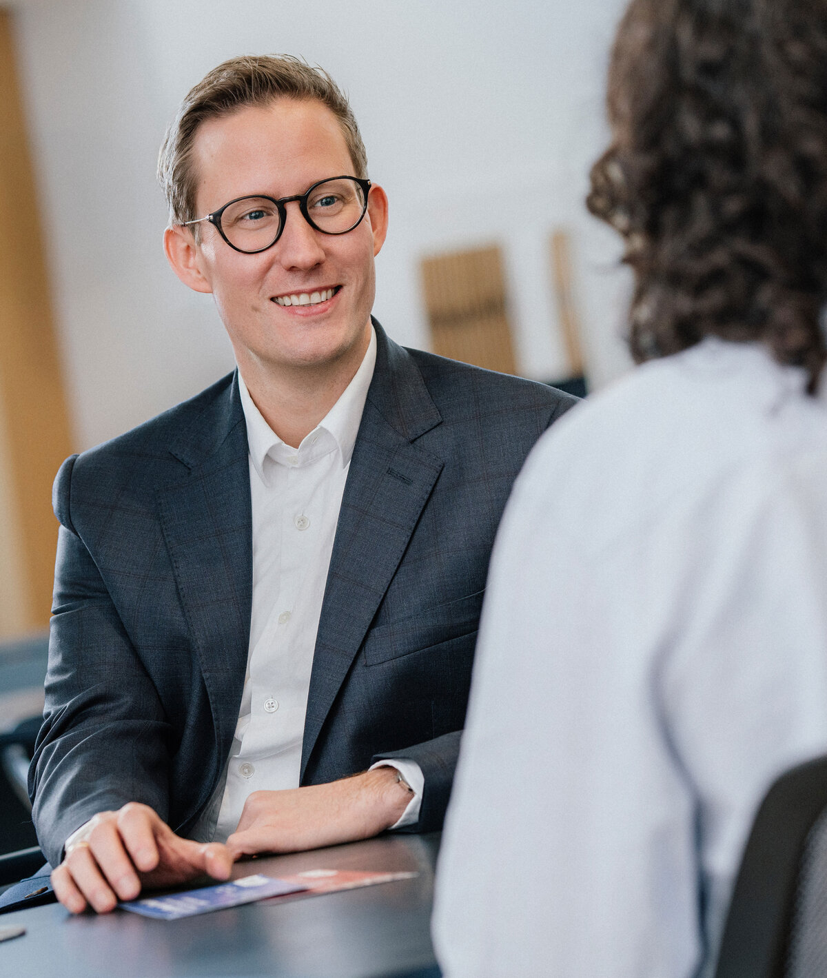 Oberbürgermeister Tobias Degode sitzt am Tisch im persönlichen Gespräch mit einer Person.