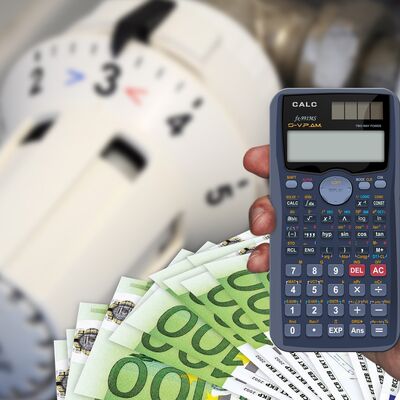 Im Vordergrund ein Taschenrechner und Geldscheine.
Im Hintergrund ein Heizungsthermostatkopf.