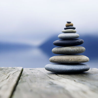 Bild vergr&ouml;&szlig;ern: Zen Balancing Pebbles Next to a Misty Lake